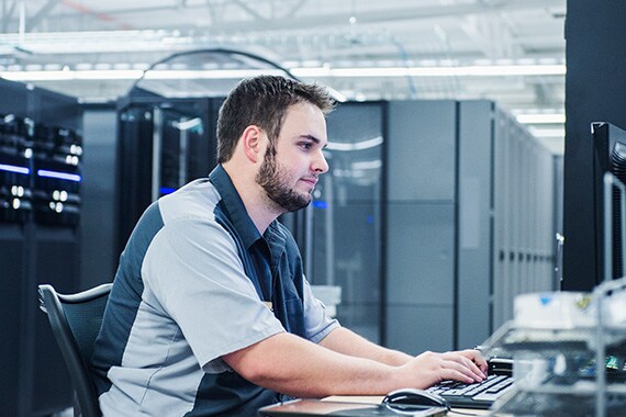 It Technician Sitting at Computer Helping Customers With CDW Data Center Goals